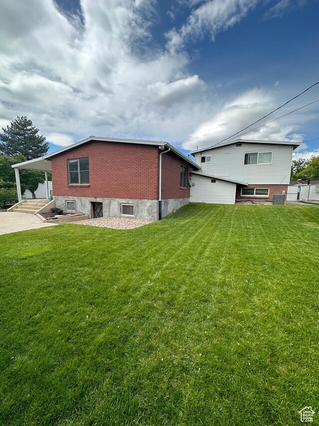 1621 W 950 N, Provo, UT 84604 - rear view of property with a yard, a carport, brick siding, and driveway