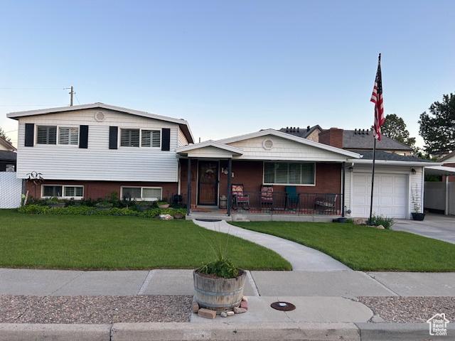 1621 W 950 N, Provo, UT 84604 - tri-level home with covered porch, a garage, a front lawn, and concrete driveway