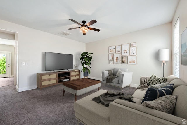 carpeted living area featuring healthy amount of natural light, a ceiling fan, and baseboards