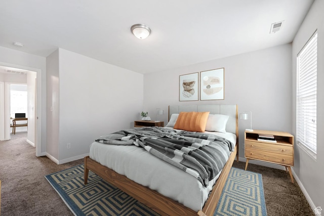 bedroom with carpet floors, multiple windows, and baseboards