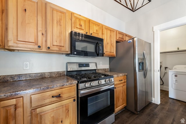 kitchen with stainless steel appliances, washer / dryer, dark wood-style floors, and dark countertops