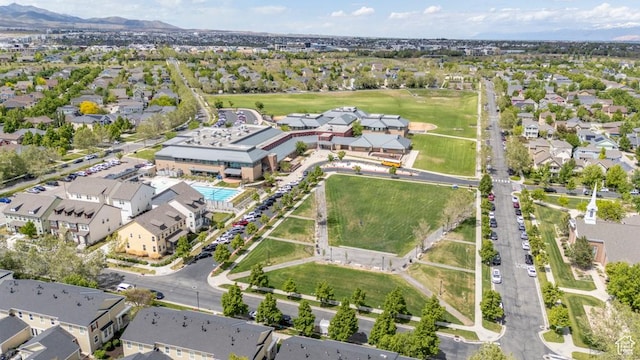 aerial view of property and surrounding area featuring a mountain backdrop and nearby suburban area