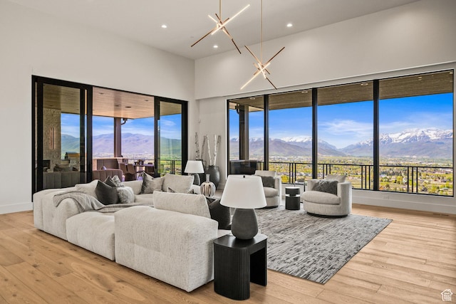 living area featuring a mountain view, light wood-style floors, healthy amount of natural light, recessed lighting, and a towering ceiling