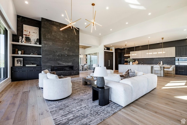 1964 E Upper Lookout Knoll Cir Unit 371, Heber City, UT 84032 - living area featuring light wood-style flooring, recessed lighting, a high end fireplace, a chandelier, and a high ceiling
