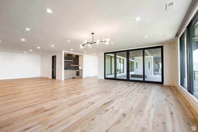 1964 E Upper Lookout Knoll Cir Unit 371, Heber City, UT 84032 - unfurnished living room with a chandelier, light wood finished floors, expansive windows, and recessed lighting