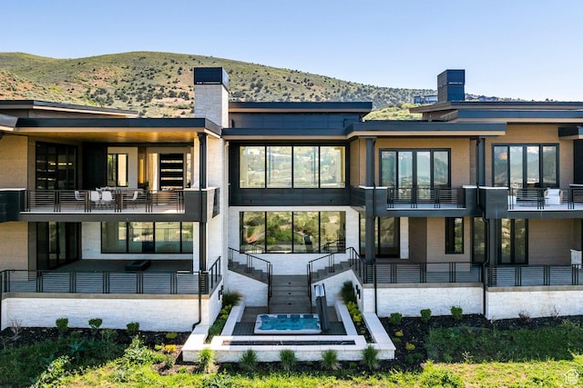 1964 E Upper Lookout Knoll Cir Unit 371, Heber City, UT 84032 - back of property featuring a balcony, a mountain view, an outdoor hot tub, and a chimney