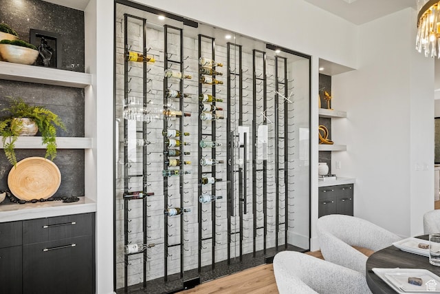 wine cellar featuring wood finished floors and a chandelier