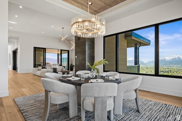 dining area with light wood-style floors, healthy amount of natural light, a chandelier, recessed lighting, and baseboards