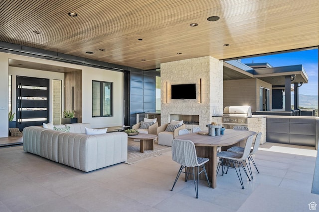 view of patio / terrace featuring area for grilling, an outdoor living space with a fireplace, and outdoor dining area