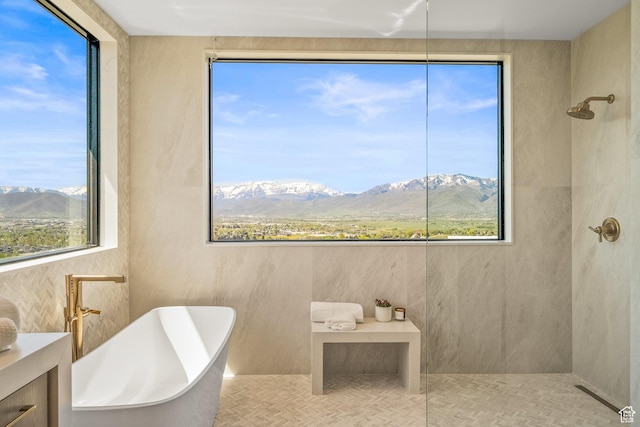 full bathroom with a mountain view, a soaking tub, and a tile shower