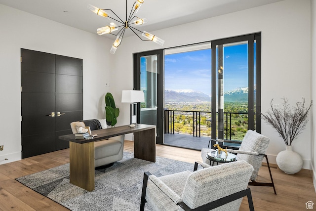 office featuring wood finished floors, a chandelier, and a mountain view