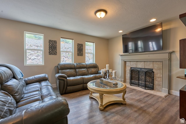 15059 S Rose Creek Ln, Herriman, UT 84096 - living area featuring wood finished floors, recessed lighting, a tile fireplace, and a textured ceiling