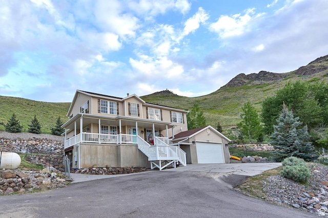 15059 S Rose Creek Ln, Herriman, UT 84096 - view of front of house featuring covered porch, stairway, driveway, and a mountain view