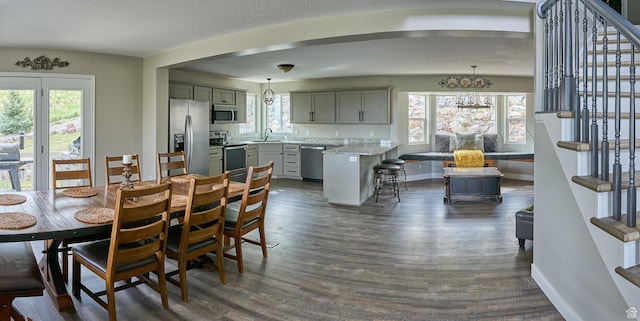 15059 S Rose Creek Ln, Herriman, UT 84096 - dining space featuring stairway, dark wood finished floors, and a chandelier
