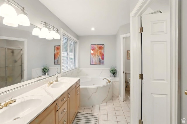 bathroom featuring a garden tub, a stall shower, double vanity, tile patterned flooring, and toilet