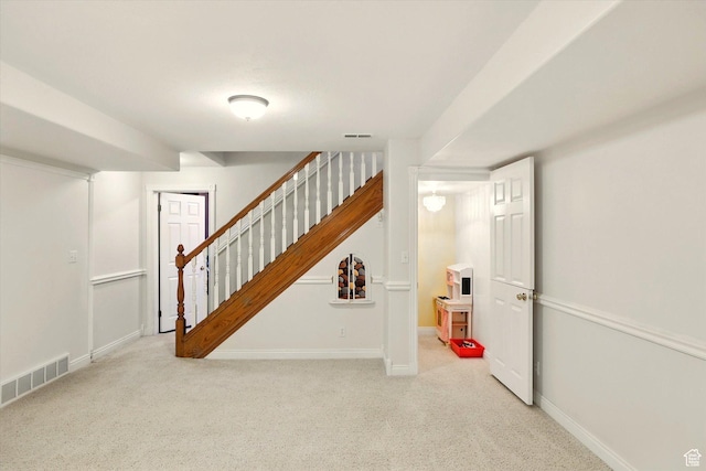 staircase featuring carpet floors and baseboards