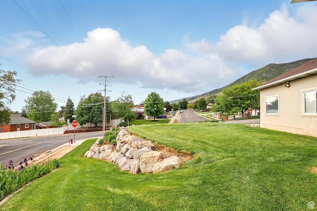 view of green lawn featuring a mountain view
