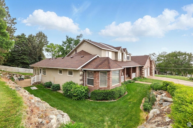view of side of home featuring stucco siding, a garage, a lawn, and a shingled roof