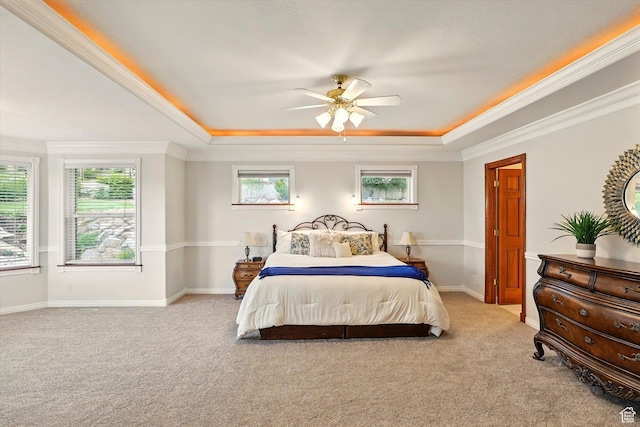 bedroom featuring a raised ceiling, light carpet, crown molding, baseboards, and a ceiling fan
