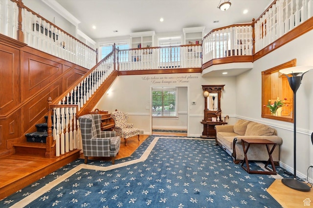 living room with stairway, wood finished floors, baseboards, and a high ceiling