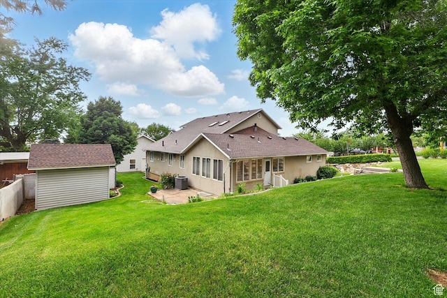 rear view of house featuring a patio, a yard, a sunroom, and an outdoor structure