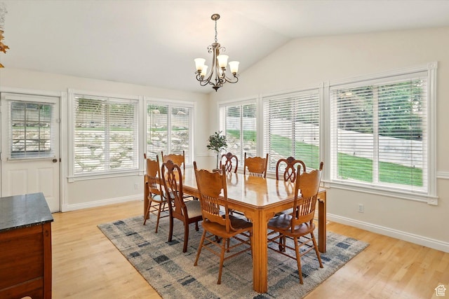 dining space with healthy amount of natural light, a chandelier, light wood-style floors, and lofted ceiling