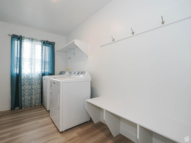 laundry room with washer and clothes dryer and light wood finished floors