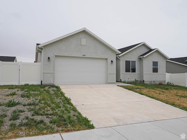 single story home featuring fence, a garage, driveway, stucco siding, and a gate