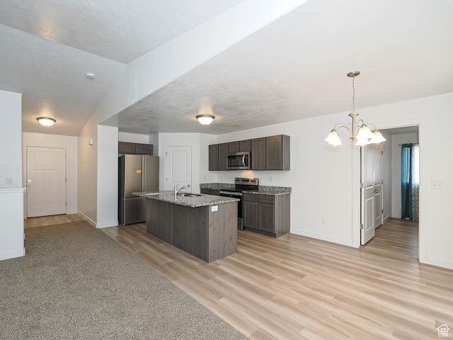 kitchen with stainless steel appliances, a sink, dark brown cabinetry, light wood-type flooring, and a chandelier