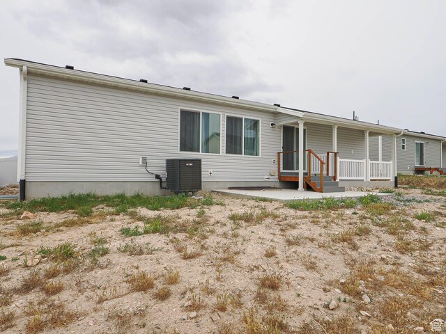back of property featuring cooling unit and covered porch