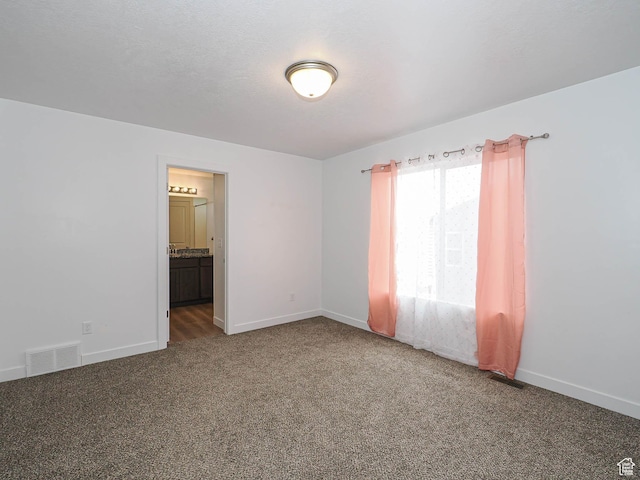 carpeted empty room featuring baseboards