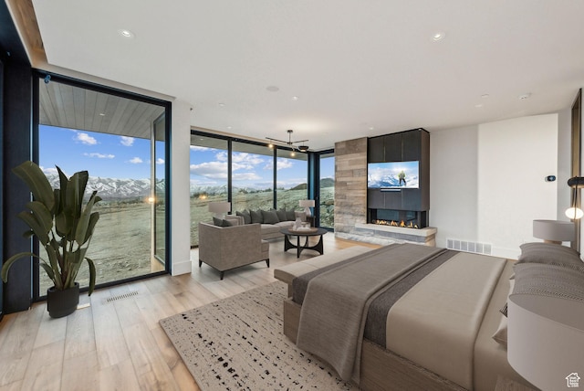 7455 N Promontory Ranch Rd, Park City, UT 84098 - bedroom featuring a wall of windows, a large fireplace, light wood-style flooring, access to exterior, and a chandelier