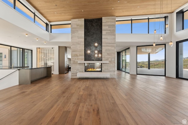 7455 N Promontory Ranch Rd, Park City, UT 84098 - unfurnished living room featuring a towering ceiling, wooden ceiling, a multi sided fireplace, and hardwood / wood-style floors