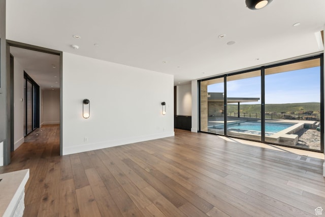 7455 N Promontory Ranch Rd, Park City, UT 84098 - spare room with floor to ceiling windows, hardwood / wood-style floors, and baseboards