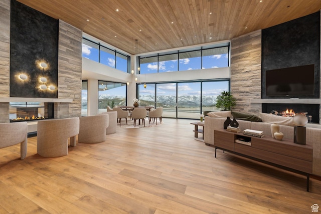 7455 N Promontory Ranch Rd, Park City, UT 84098 - living area featuring a multi sided fireplace, wood ceiling, a high ceiling, wood finished floors, and recessed lighting