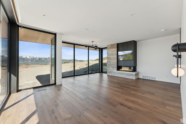 7455 N Promontory Ranch Rd, Park City, UT 84098 - unfurnished living room with a wall of windows, wood finished floors, a large fireplace, and a mountain view