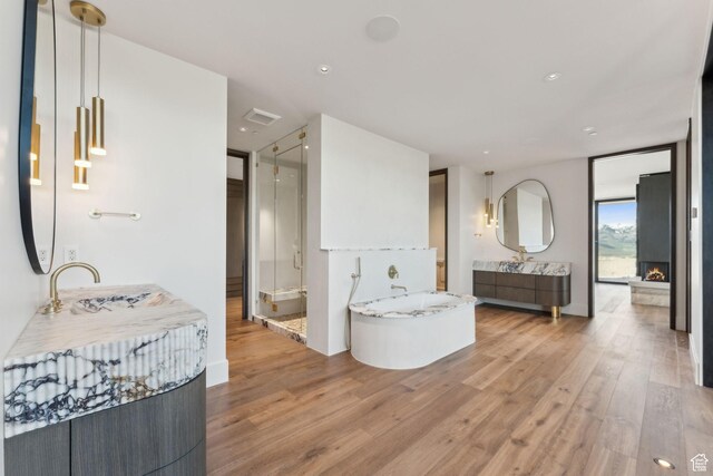 7455 N Promontory Ranch Rd, Park City, UT 84098 - full bath with wood finished floors, a shower stall, a bath, two vanities, and recessed lighting