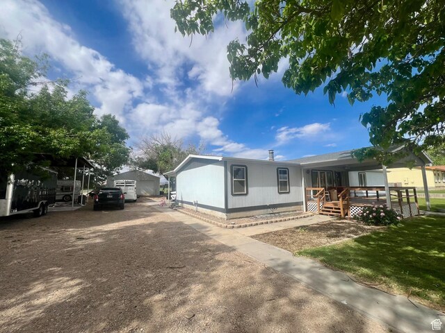 465 E Kings Ln, Green River, UT 84525 - view of front of property with an outdoor structure, a detached garage, dirt driveway, and covered porch