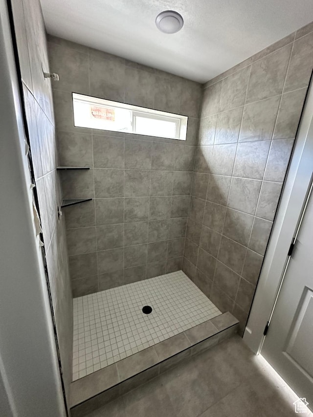 bathroom featuring a tile shower and plenty of natural light