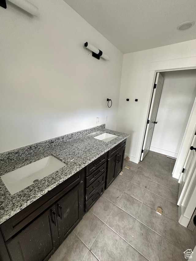 full bathroom with tile patterned flooring, double vanity, and baseboards