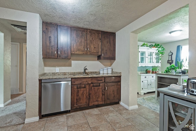 1154 S Montgomery St W, Salt Lake City, UT 84104 - kitchen featuring stainless steel dishwasher, a sink, a textured ceiling, baseboards, and light stone counters