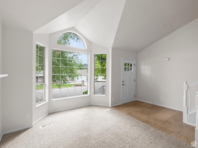 carpeted entrance foyer featuring vaulted ceiling and baseboards