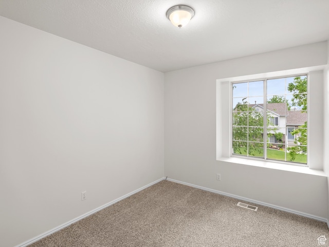 carpeted spare room featuring baseboards