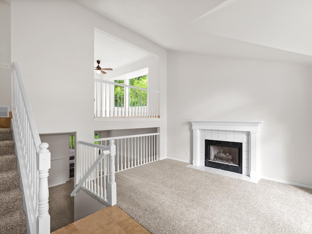 unfurnished living room with carpet floors, lofted ceiling, a ceiling fan, a fireplace, and baseboards