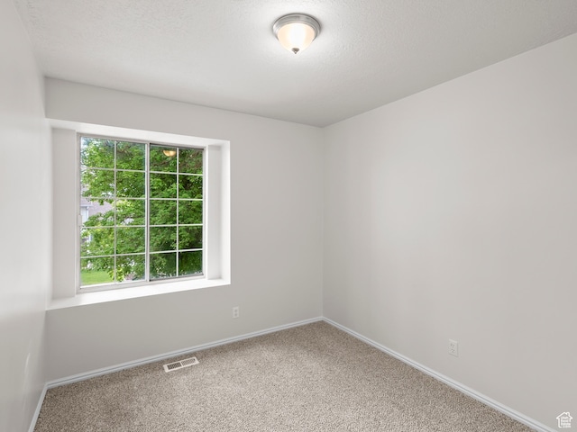 spare room featuring baseboards and carpet