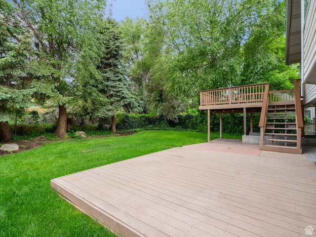 wooden deck featuring stairs and a yard