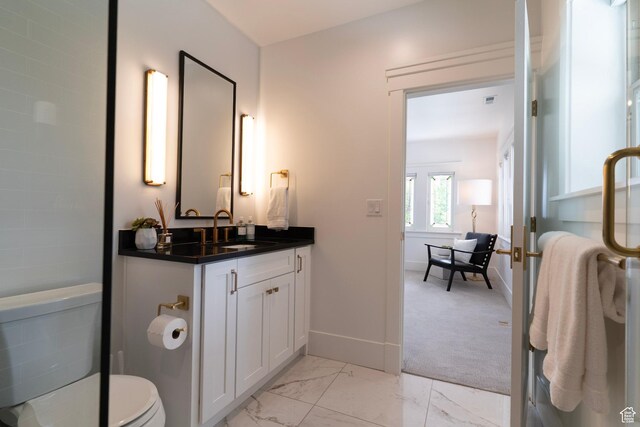 158 N State St, Salt Lake City, UT 84103 - bathroom with marble look tile flooring, vanity, toilet, and baseboards