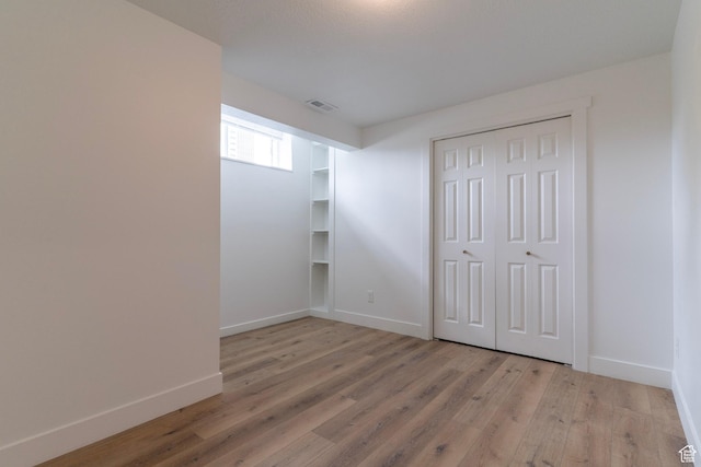 158 N State St, Salt Lake City, UT 84103 - unfurnished bedroom with light wood-type flooring, baseboards, and a closet