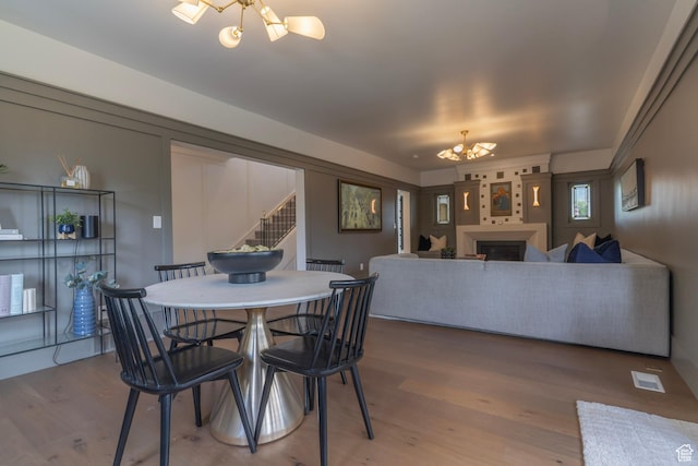 158 N State St, Salt Lake City, UT 84103 - dining room with a chandelier, stairs, wood finished floors, and a fireplace