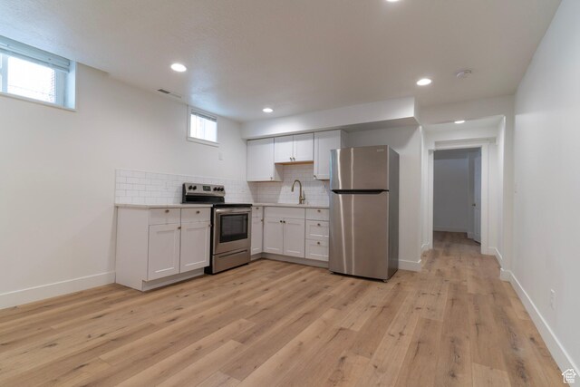 158 N State St, Salt Lake City, UT 84103 - kitchen featuring stainless steel appliances, a sink, white cabinetry, light countertops, and decorative backsplash
